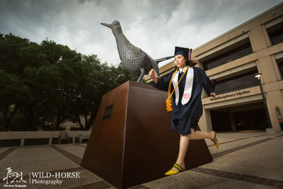 Graduation girl running with roadrunner at UTSA campus.